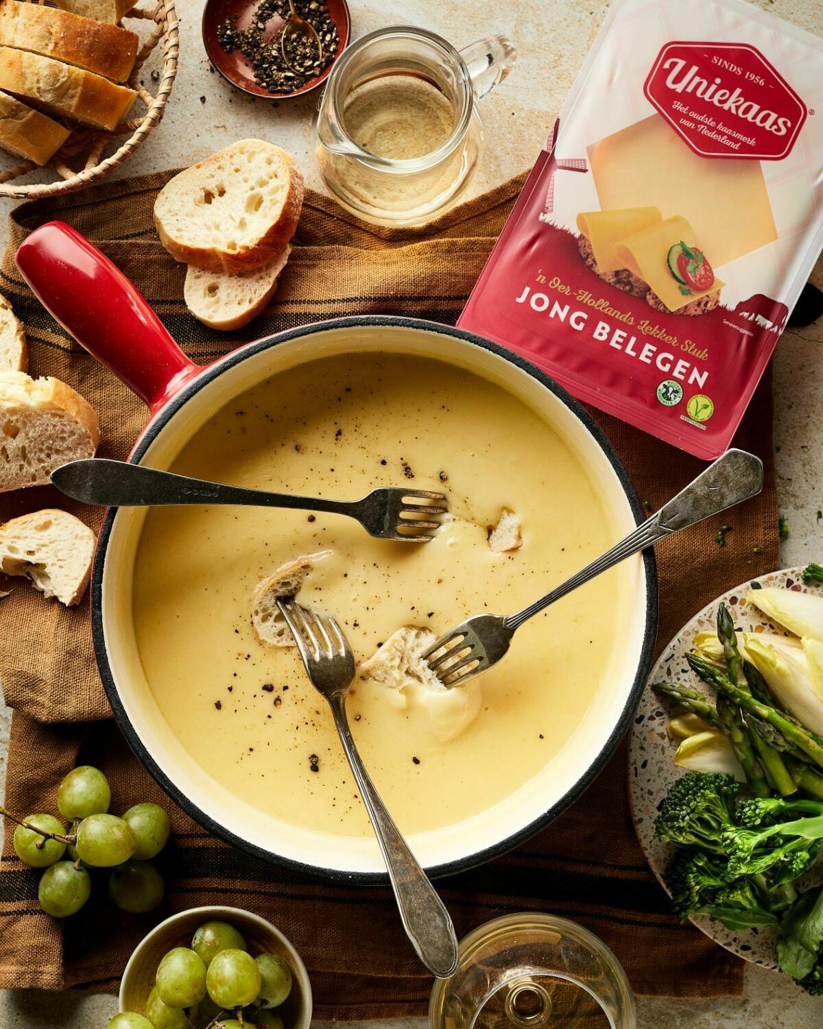Kaasfondue met geraspte kaas en Italiaanse kruiden