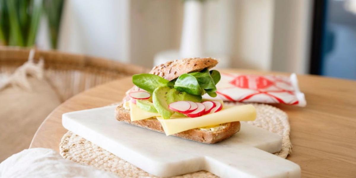 Hard broodje met pompoenpitten, radijs, avocado en veldsla